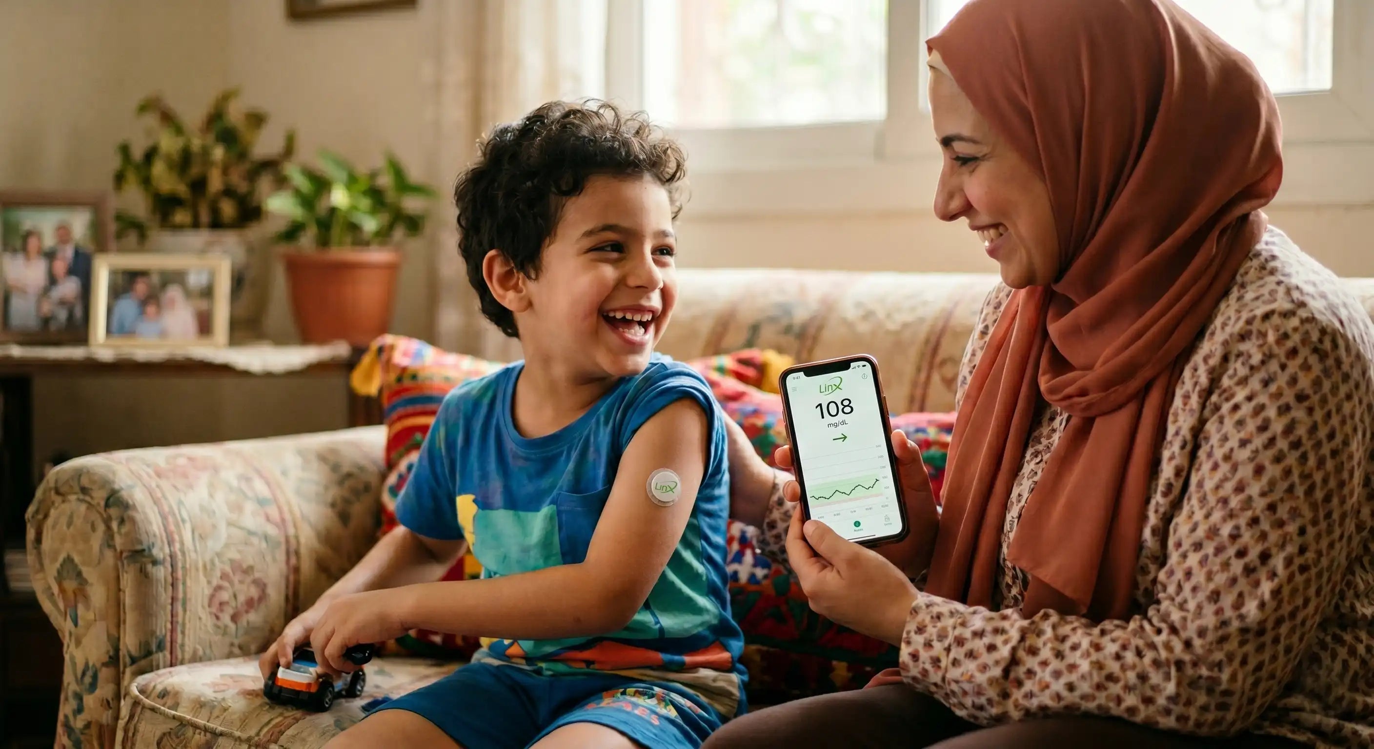 A smiling mother checks her happy son's arm sensor reading on a smartphone. LINX CGM BEST SENSOR PRICE IN EGYPT.