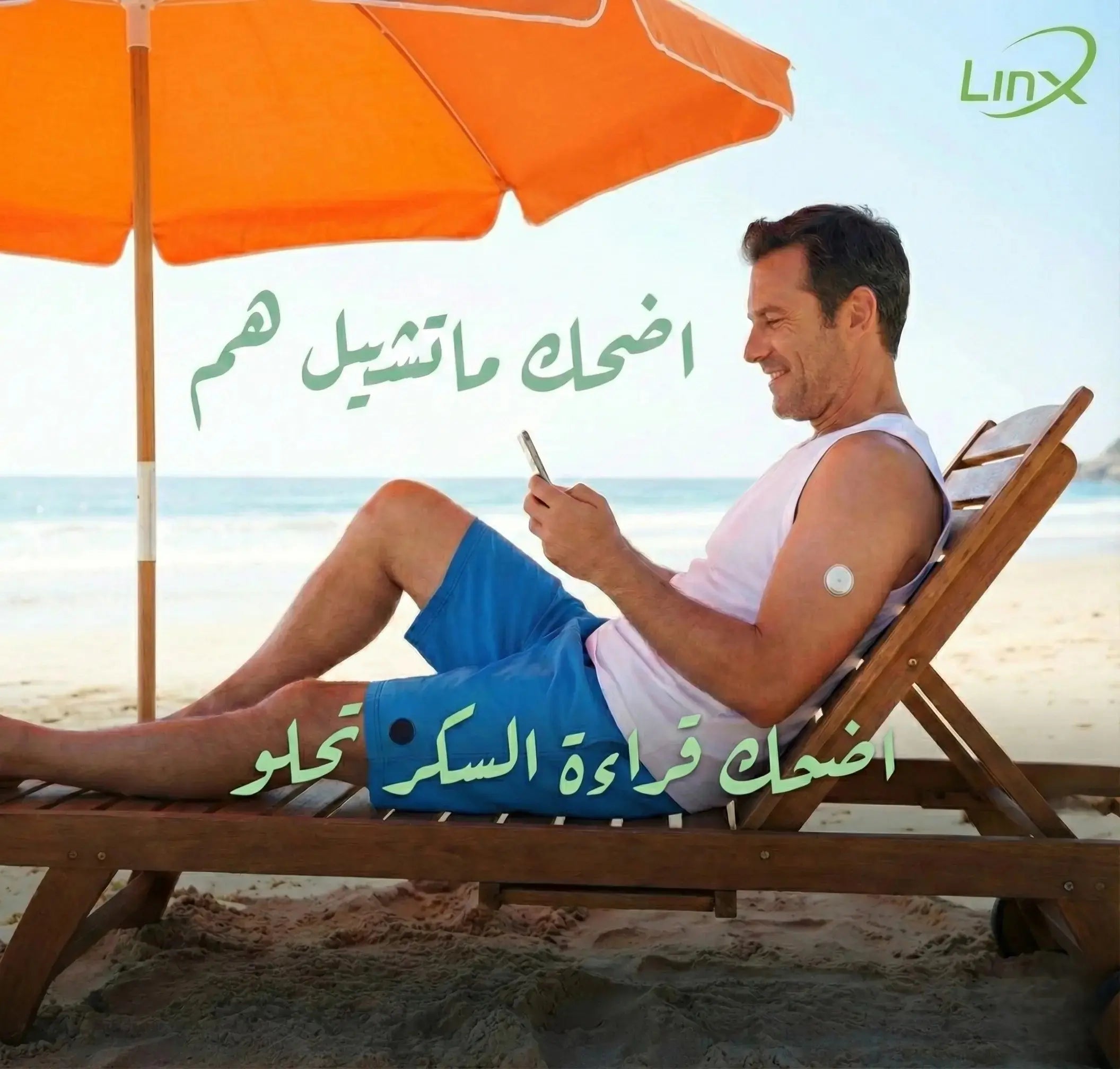 Smiling man with arm sensor relaxes on beach chair, checking phone under orange umbrella